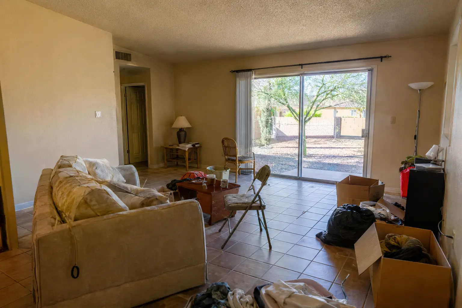Illustrative before image of left-behind furniture and household contents in a Phoenix rental living room